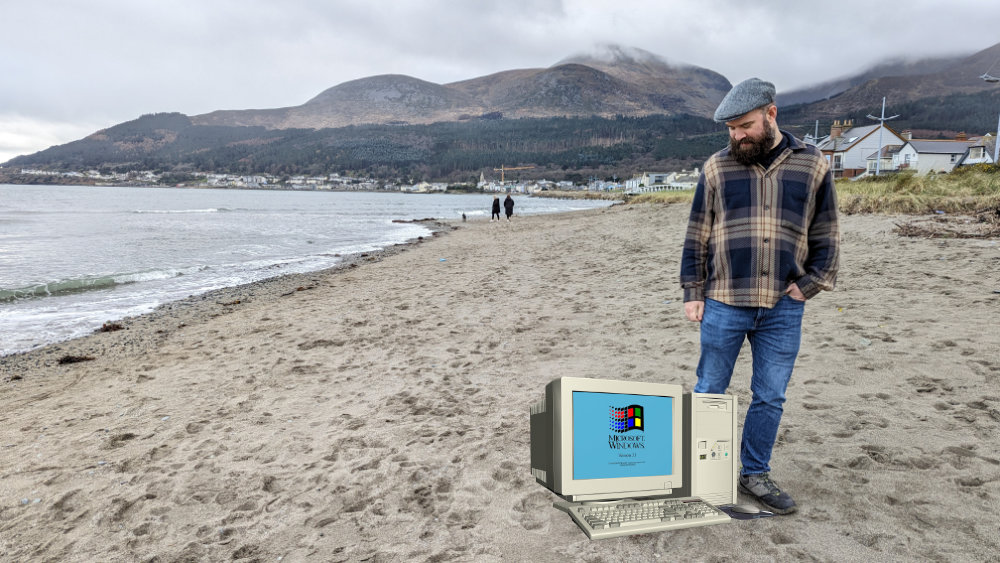 Davey Faherty on a beach with a computer